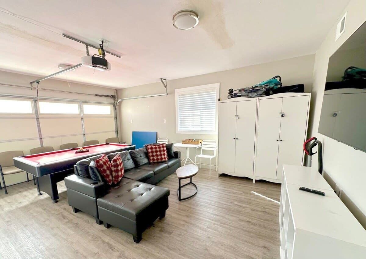 Een kamer met een pooltafel, een bank, een klein rond tafeltje en een kast.