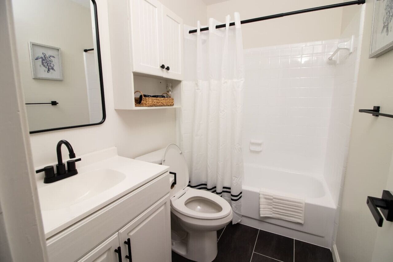 A bathroom with a white sink, toilet, and bathtub.