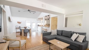 A modern living room with a grey sofa, wooden coffee table, and a dining area with a table and chairs. - *Update * New Game Room, near Navy Base and Beach! (Atlantic Beach)