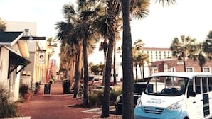 A street with palm trees, a blue van labeled 'BUGGY,' and buildings in the background. - *Update * New Game Room, near Navy Base and Beach! (Atlantic Beach)