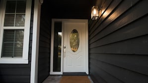 A dark wooden house with a white door featuring a glass panel and a brass doorknob. - *Update * New Game Room, near Navy Base and Beach! (Atlantic Beach)