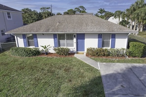 Stylish single-story home with a gabled roof and a clean design, featuring a front entrance and a well-manicured lawn.