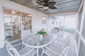 Enjoy a dining experience in this serene outdoor space with a round table and comfortable seating.