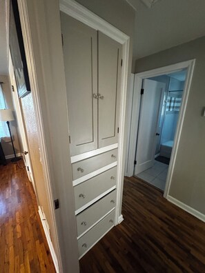 A hallway with a white wardrobe, wooden flooring, and a door leading to another room. - Perfect Location 5 minutes from everything CDA (Coeur d'Alene)