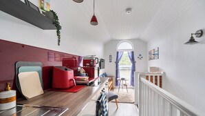 Un espacio habitable compacto con kitchenette, comedor y vistas por una ventana.