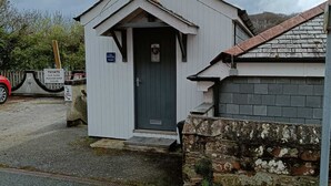 En liten, envåningsbyggnad med en mörk dörr och en skylt som visar att det är en privat parkeringsplats.