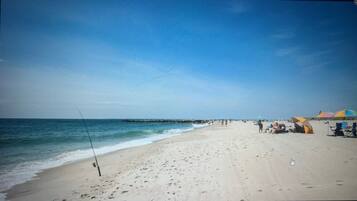 A beach with a fishing rod, umbrellas, and people.