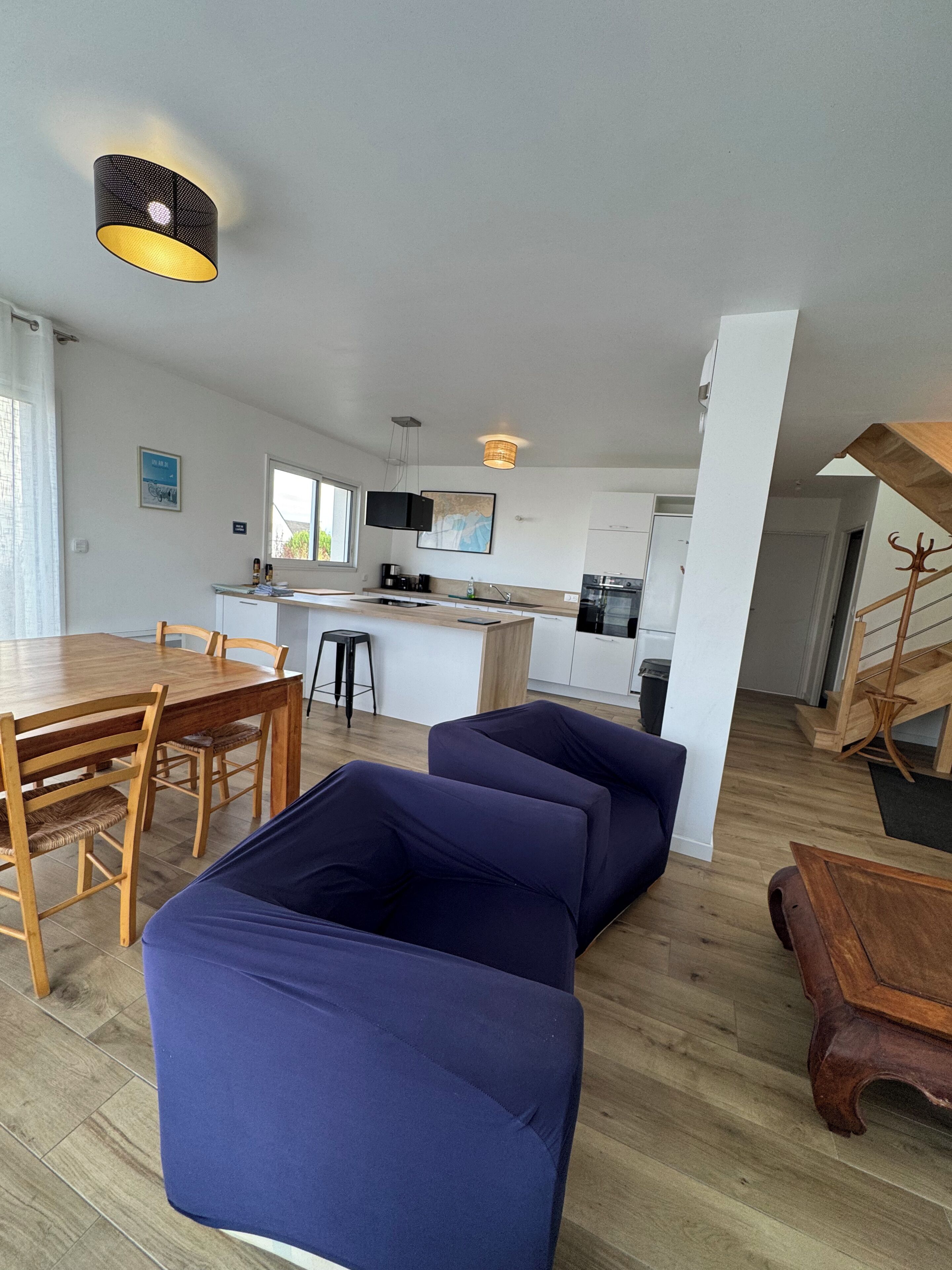 Un espace de vie moderne comprenant un coin repas, une cuisine et un escalier.