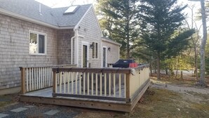 Une maison avec une terrasse en bois, un garage et un espace extérieur abrité.