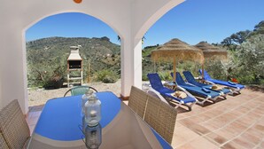 Eine Terrasse mit Tisch, Stühlen und Blick auf einen Berg.