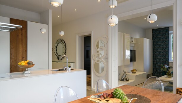 A modern kitchen with white cabinetry, a wooden island, and a dining area with a wooden table and clear chairs. - ★FRAMAR apartment★ close to Old town, beach 300 m (Dubrovnik)
