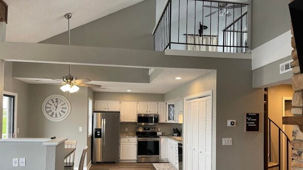 A spacious kitchen with modern appliances, a dining area, and a staircase leading to an upper level.