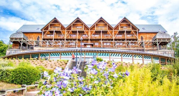 A wooden lodge with a large balcony and a covered walkway.