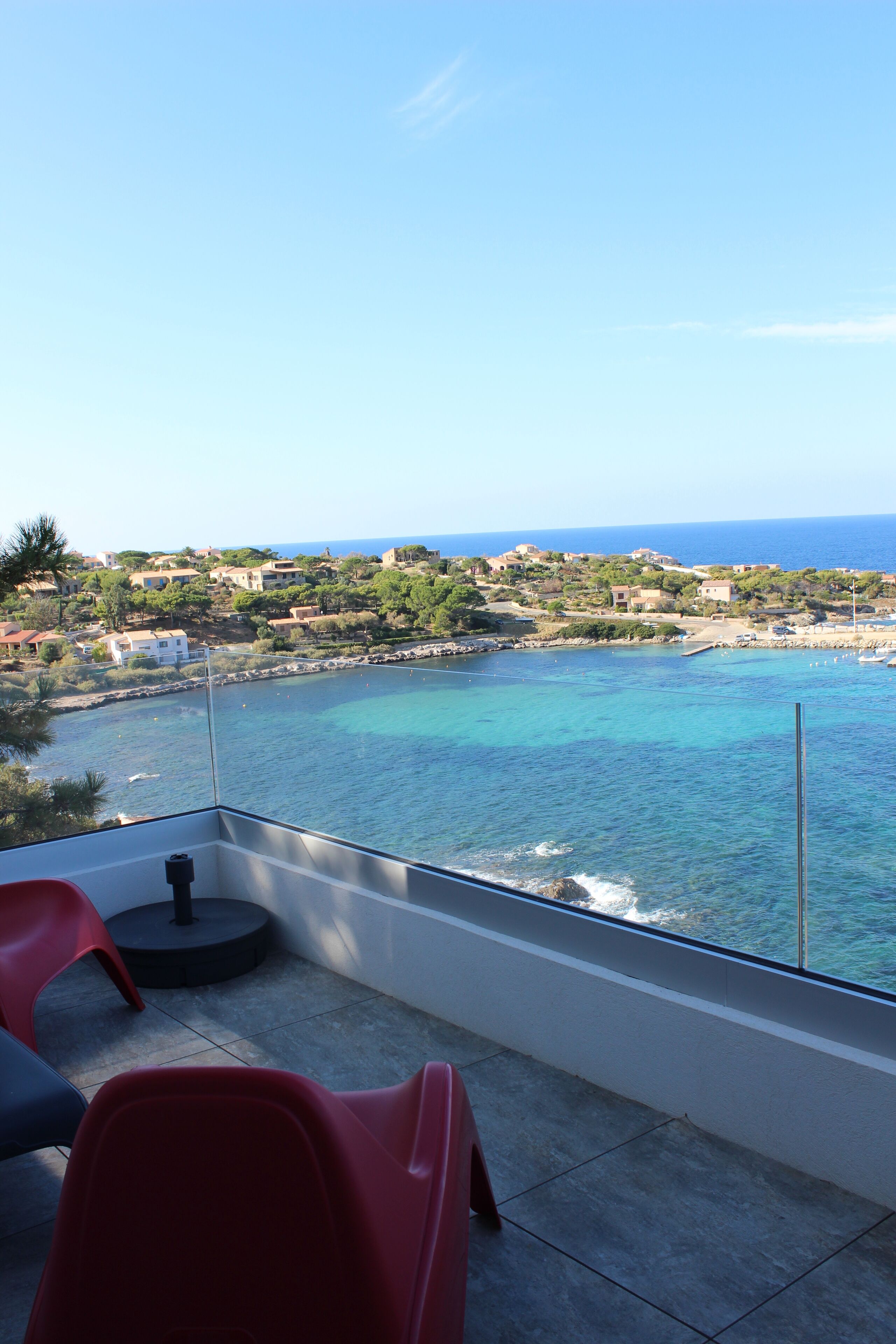Un balcon offrant une vue dégagée sur la mer et une ville côtière.