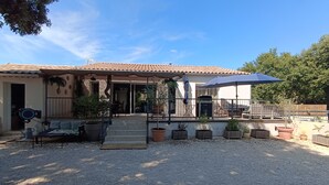 A house with a patio, outdoor seating, and potted plants. - House close to activities and tourist sites (Labastide-de-Virac)