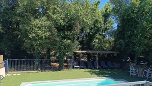 A backyard with a swimming pool, a covered seating area, and a fenced garden. - House close to activities and tourist sites (Labastide-de-Virac)
