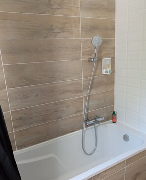 Bathtub, hair dryer, towels, toilet paper