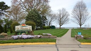 A private entrance to Old Homestead II with a sign indicating it's members only, a pathway leading to a grassy area, and a 'No Dogs Allowed' sign. - Sandy Neighborhood Private Beach Getaway in Huron (Huron)