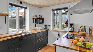Una cucina moderna con piani di lavoro in legno, forno a microonde integrato e macchina per il caffè.