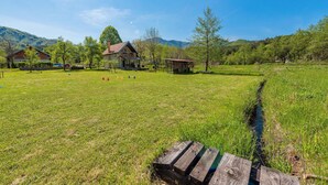 Paesaggio rurale con un campo erboso, una recinzione in legno e una piccola costruzione in legno.