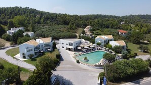 Ein Resort mit Schwimmbad, mehreren Gebäuden und einer umliegenden Waldlandschaft.