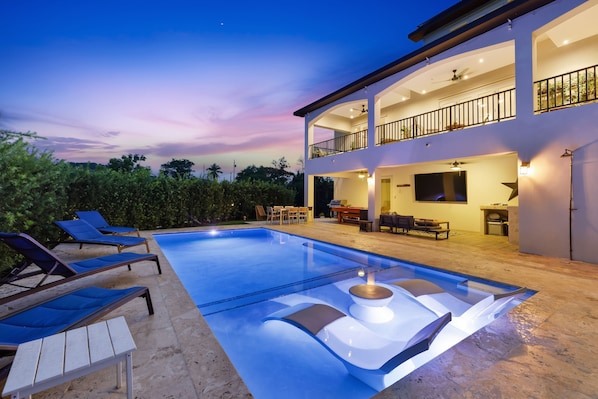A two-story house with a swimming pool, outdoor furniture, and a balcony. - Luxury Estate with Heated Pool & el Yunque Views (Luquillo)