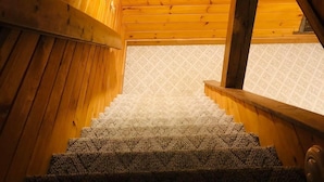 A wooden staircase with a framed picture on the wall above.