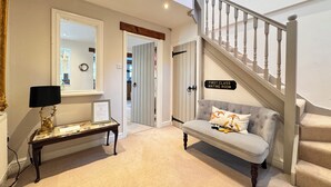 A hallway with a mirror, a bench, a sofa, and a staircase. - Comfortable 6 Guest Home - Walk to Canal & Award-Winning Pub (Weston-on-Trent)