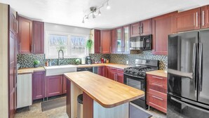 A modern kitchen with wooden countertops, stainless steel appliances, and a central island. - Waterfront home with dock, pool and hot tub! NOTRE DAME FOOTBALL (Osceola)