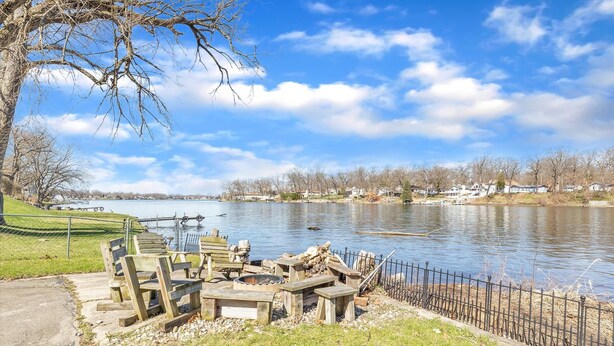 A lakeside park with wooden benches and a picnic table, a metal grill, and a fence along the water's edge. - Waterfront home with dock, pool and hot tub! NOTRE DAME FOOTBALL (Osceola)