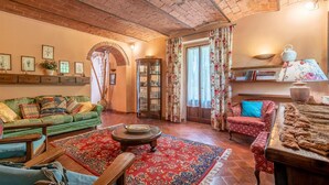 A cozy living room with a green sofa, a red patterned rug, and a wooden coffee table. - Cozy apartment in Molino del Piano (Molino del Piano)