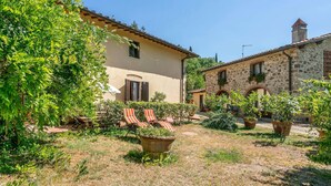 A courtyard with a stone building, a beige house, and a flagstone pathway. - Cozy apartment in Molino del Piano (Molino del Piano)