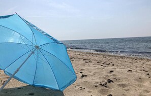 A beach scene with a blue umbrella on the sand. - 2 bedroom pet friendly home in Köpingebro (Köpingebro)