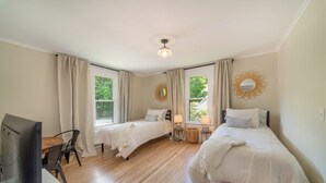 Une chambre avec deux lits, un bureau et une chaise.
