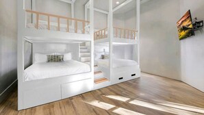 Una habitación con literas, una escalera y un cuadro en la pared.