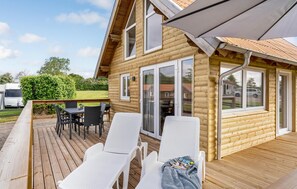 Relax on the deck with a view of the surrounding area, featuring a comfortable seating area and dining space.