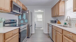 Une cuisine moderne avec des meubles en bois, des appareils en acier inoxydable et un îlot central.