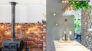 A cozy room with a brick fireplace, modern decor, and a stone accent wall. - Desert Ruby: Stargaze, Spacious, Hot Tub, Fire pit, Fenced, Pet Friendly (Yucca Valley)