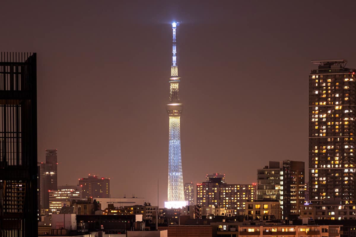 A high-rise building with a prominent tower, surrounded by other buildings.