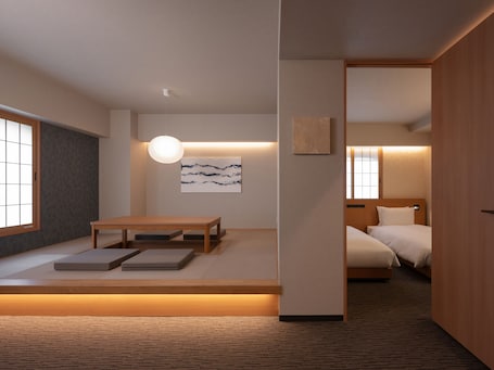 A modern hotel room with a wooden floor, a bed, a bedside table, a desk, and a chair. There is a window with a view of the outside.