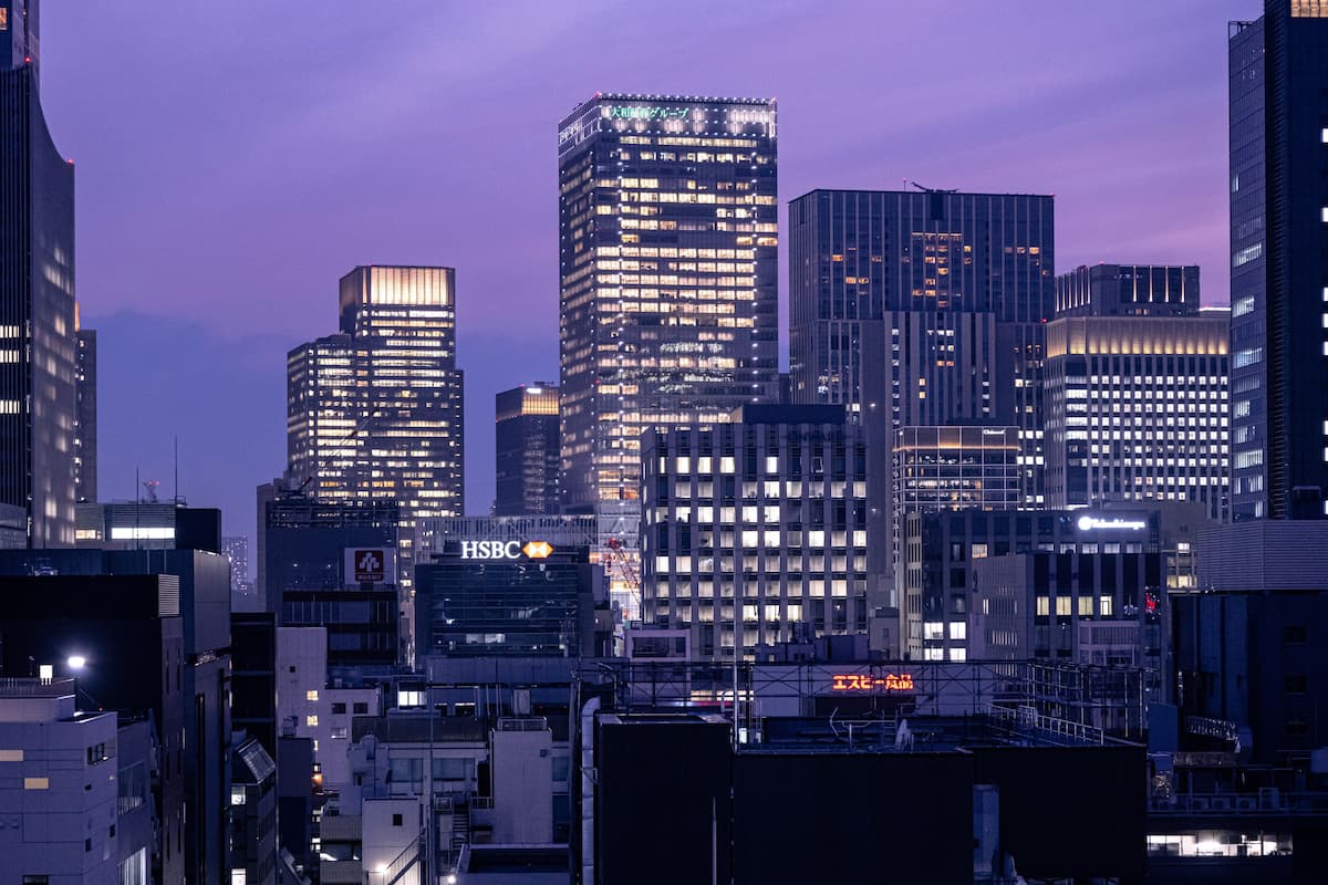 A cityscape with modern high-rise buildings, including a prominent HSBC bank building.