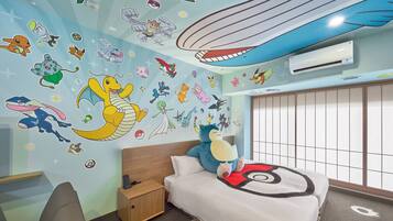 A bedroom with a bed, a nightstand, a large plush toy, and a wall decorated with various cartoon characters and designs.