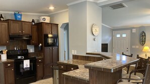 A kitchen with dark wooden cabinets, a black stove, and a granite countertop. - Family fun! Beach, Kayaking, yard games, large fenced yard, fire pit. 2 mi beach (Ocean View)