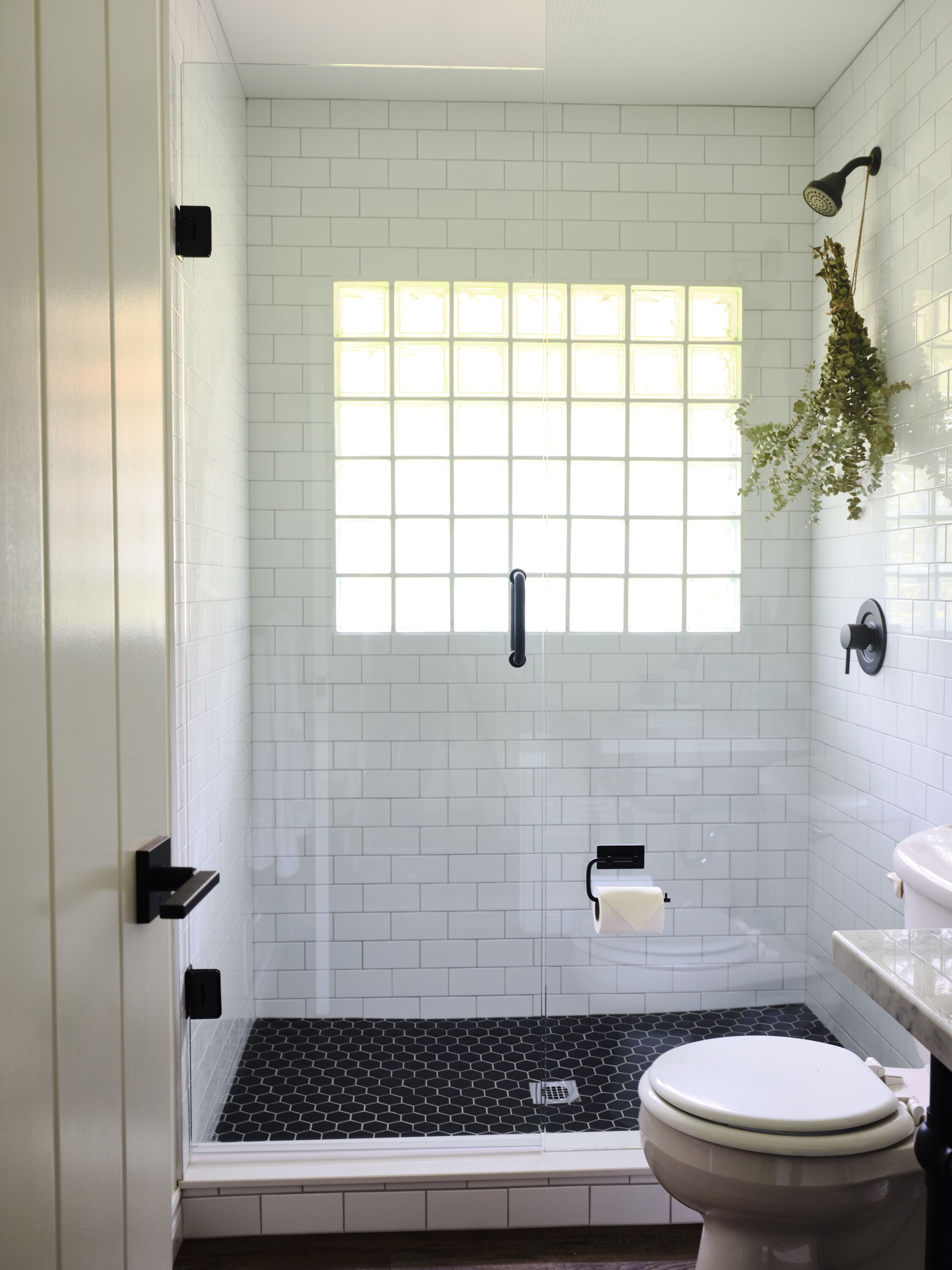 A bathroom with a shower, toilet, and sink.