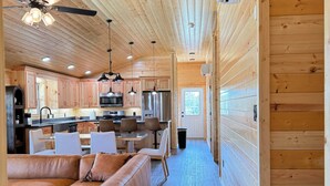 Un interior de madera con cocina, comedor y sofá.