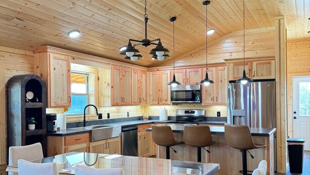 Una cocina moderna con armarios de madera, electrodomésticos de acero inoxidable y una isla central con asientos.