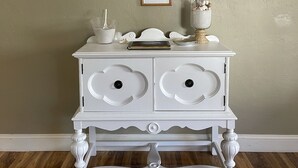 A white dresser with two drawers, a framed welcome sign, and a small framed note on the wall. - Sarasota Gateway Beach House (Sarasota)