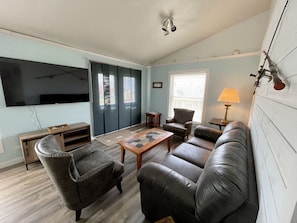 Relax in style with a comfortable seating area, large flat-screen TV, and sliding glass door to a balcony with a view.