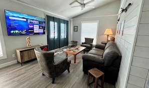 Relax in this stylish living room with a flat-screen TV, comfortable sofa, and armchair.