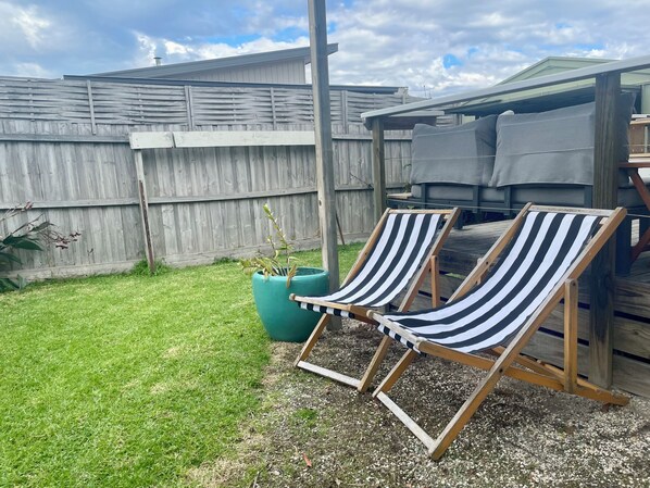 Two striped lounge chairs, a green planter, and a wooden deck. - Marjalis Cottage, your perfect country getaway! (Wonthaggi)